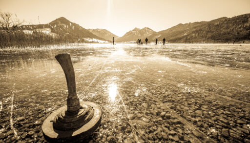 an ice stock paddle on a frozen lake with mountains in the background