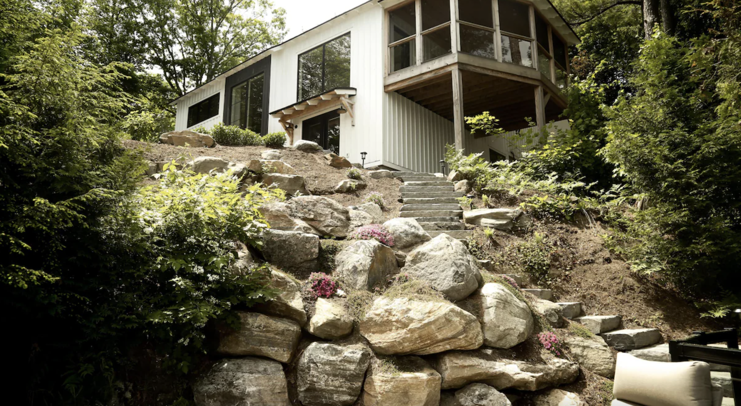 the outside of the cottage with a rock pathway in the foreground