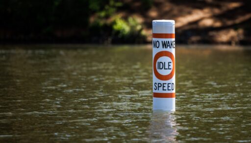 No wake safety buoy on lake alerting boaters to idle speed restriction.